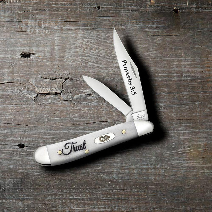 Case Religious Sayings Trust Peanut pocket knife with Clip and Pen blades open on a rustic wood surface, Proverbs 3:5 on the main blade and Trust script on the smooth natural bone handle