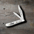 Case Religious Sayings Trust Peanut pocket knife with Clip and Pen blades open on a rustic wood surface, Proverbs 3:5 on the main blade and Trust script on the smooth natural bone handle