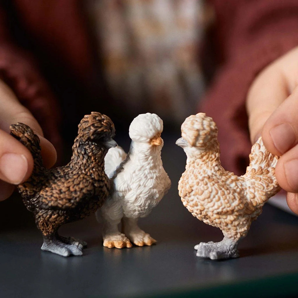 Child playing with three Schleich Chicken Friends figures