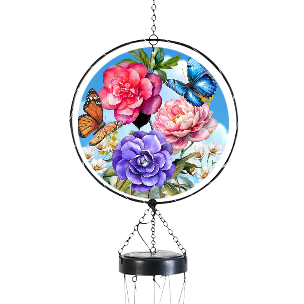 Close-up of the glass light catcher with blue and orange butterflies, pink and purple peonies, and a black circular frame.