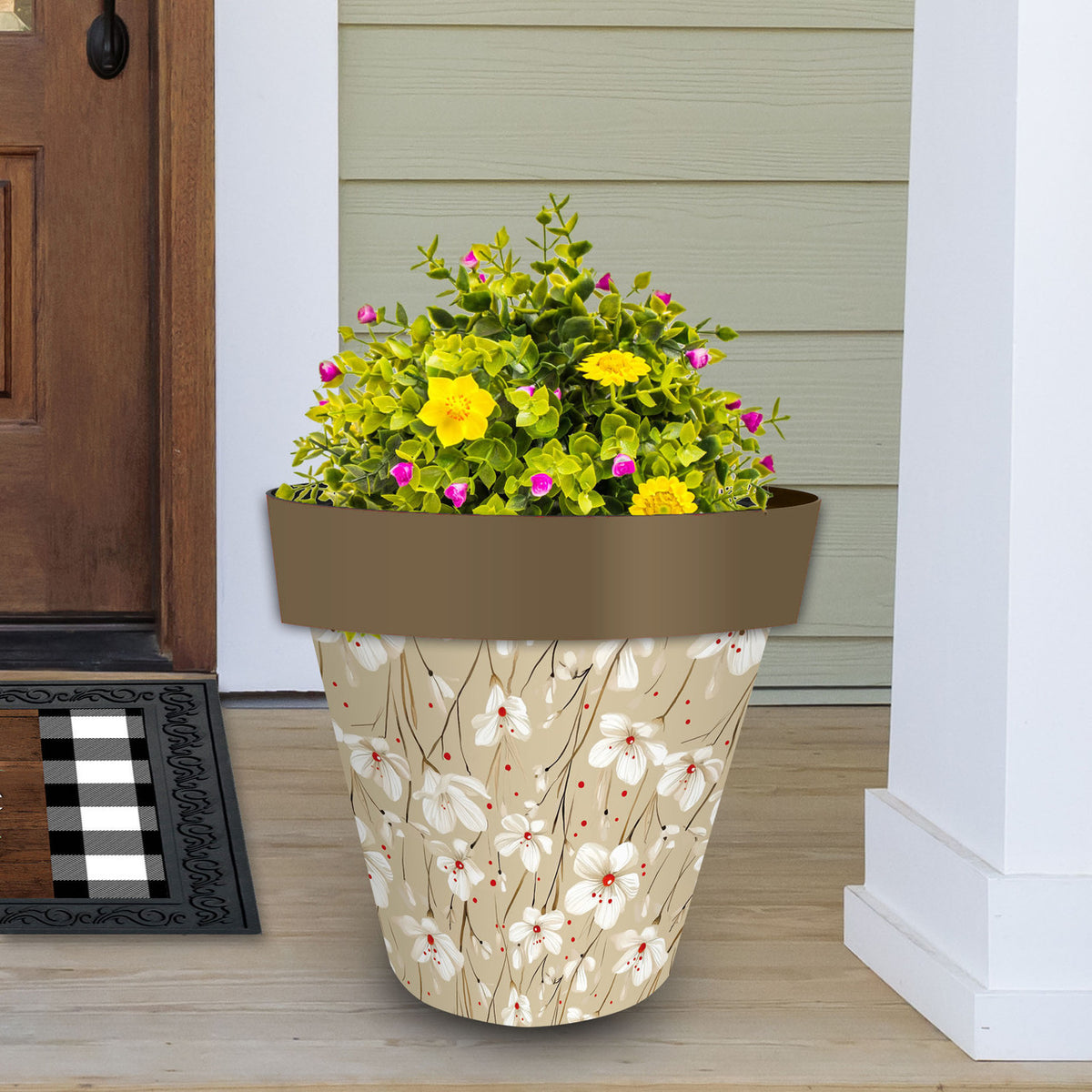 Large tan floral planter filled with yellow and pink flowers beside a front door.
