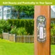 A close-up of a bronze metal post featuring a circular emblem with an anchor and the text 'MONT BLANC', set against a blurred background of green grass and trees.