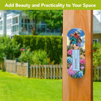 A decorative vertical garden thermometer mounted on a wooden post in a backyard setting, featuring colorful birdhouse and flower graphics