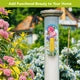 Butterflies and Peonies metal thermometer displayed on a garden post among blooming flowers.