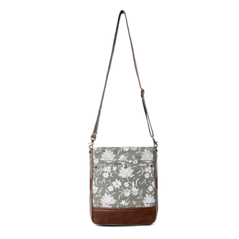 Full view of Myra Blossom Print Shoulder Bag with gray floral canvas, brown leather trim and adjustable shoulder strap
