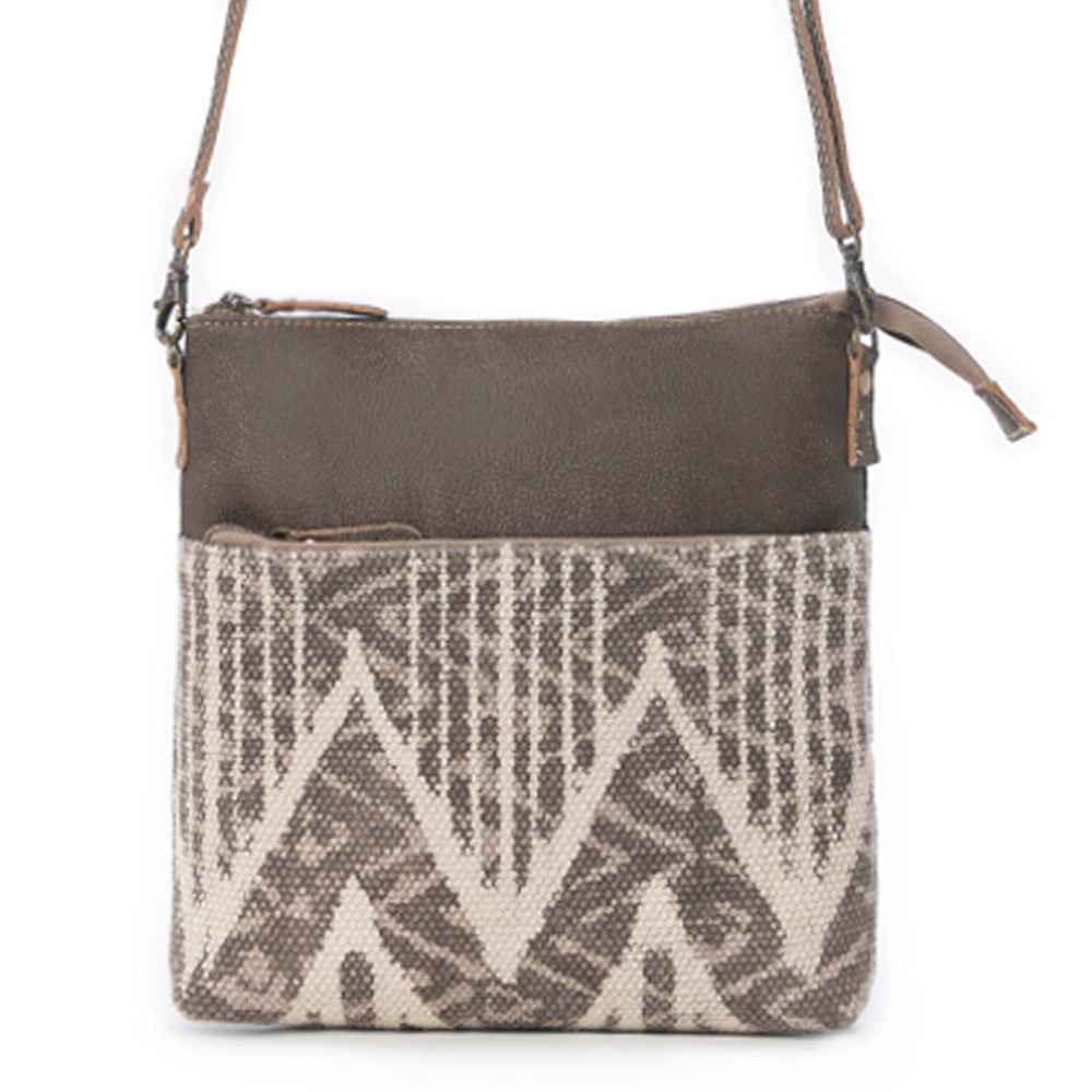Front view of Myra Coffee Canvas Crossbody Bag with brown leather top and neutral geometric rug design