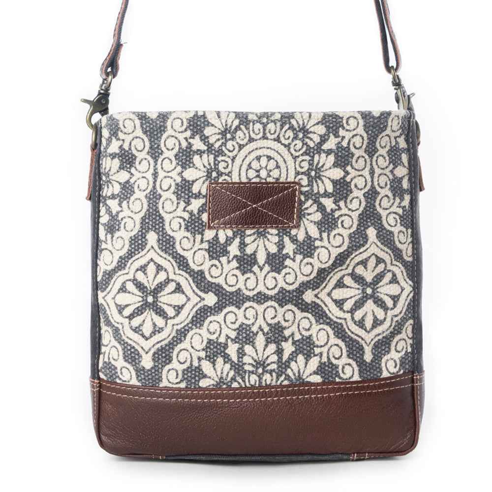 Front view of Myra Freaky Leather Shoulder Bag with cream and dark floral rug pattern and brown leather accents