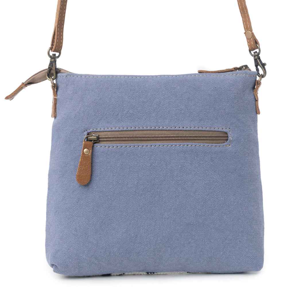 Back view of Myra Itsy Bitsy Crossbody Bag with blue canvas and exterior zipper pocket
