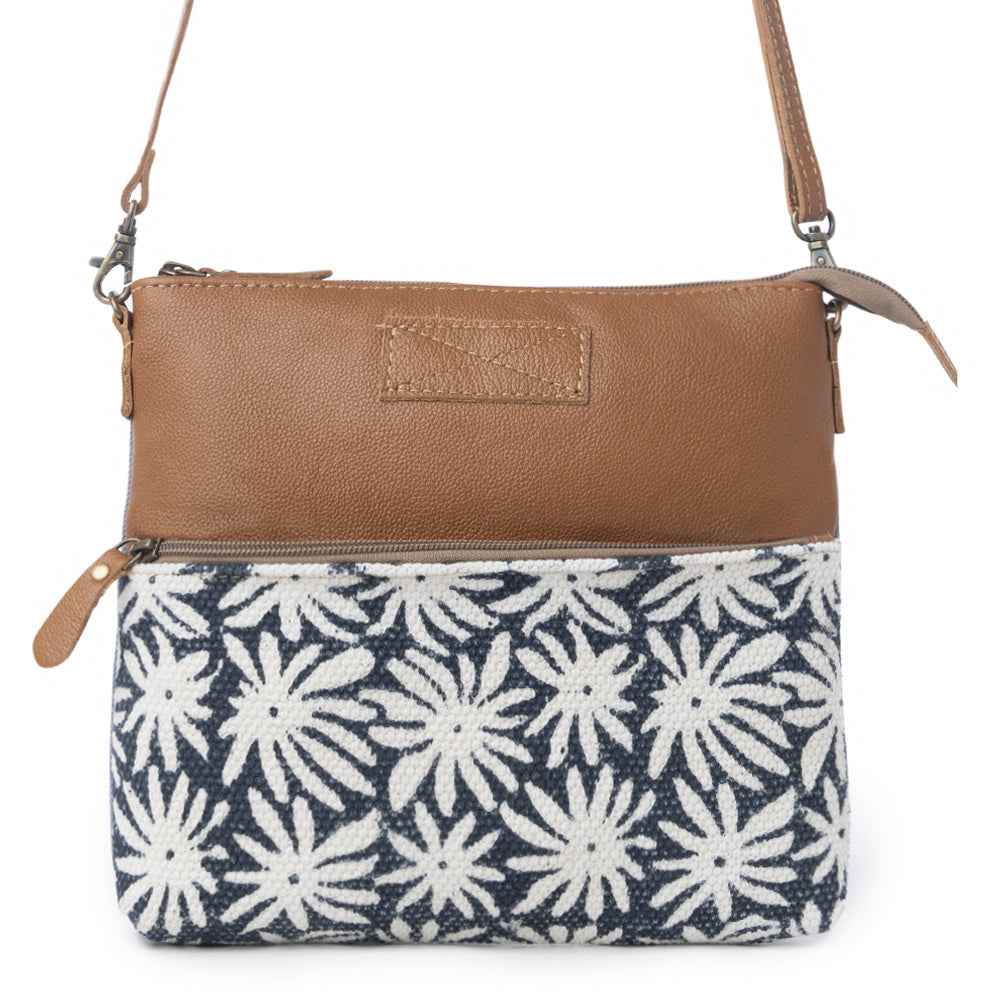Front view of Myra Itsy Bitsy Crossbody Bag with white floral rug design, brown leather and adjustable strap