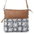 Front view of Myra Itsy Bitsy Crossbody Bag with white floral rug design, brown leather and adjustable strap