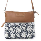 Front view of Myra Itsy Bitsy Crossbody Bag with white floral rug design, brown leather and adjustable strap