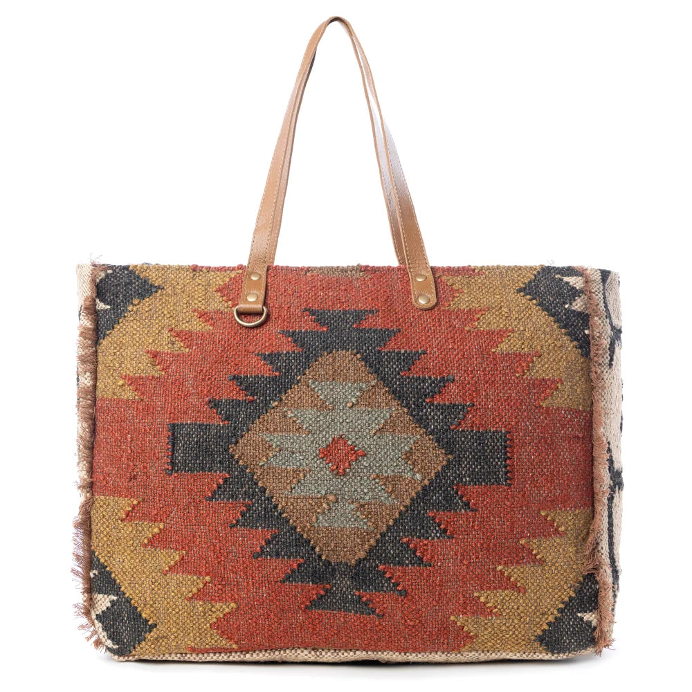 Front view of the Myra Kaliko Hill Canvas Weekender Bag featuring a colorful Southwestern boho pattern and dual leather shoulder handles.