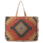 Front view of the Myra Kaliko Hill Canvas Weekender Bag featuring a colorful Southwestern boho pattern and dual leather shoulder handles.