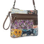 Angled view of Myra Le Piccolo Crossbody Bag with colorful floral canvas, genuine leather accents and wrist strap