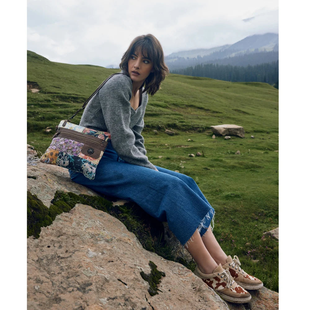 Lifestyle view of Myra Le Piccolo Crossbody Bag with colorful floral patchwork canvas and brown leather accents