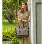 Myra Mystique canvas leather messenger bag styled with dual shoulder handles and floral print.