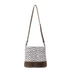 Full view of Myra Precision Crossbody Bag with black and white geometric rug design, genuine leather trim and adjustable shoulder strap