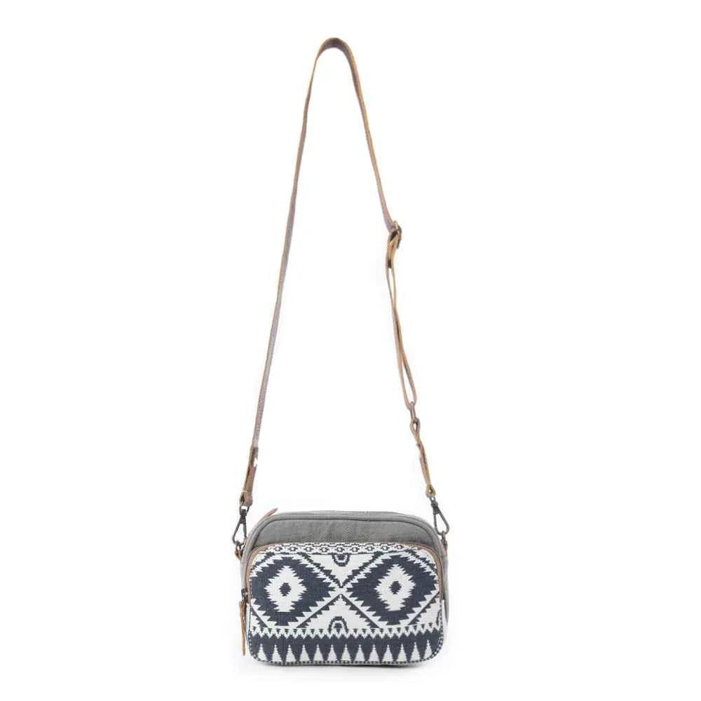 Full view of the Myra Temptation Tribal Crossbody Bag with black and white geometric pattern and adjustable leather shoulder strap.
