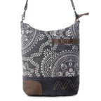 Front view of Myra Vintage Carved Shoulder Bag featuring black and white vintage print, brown leather accent and dark canvas