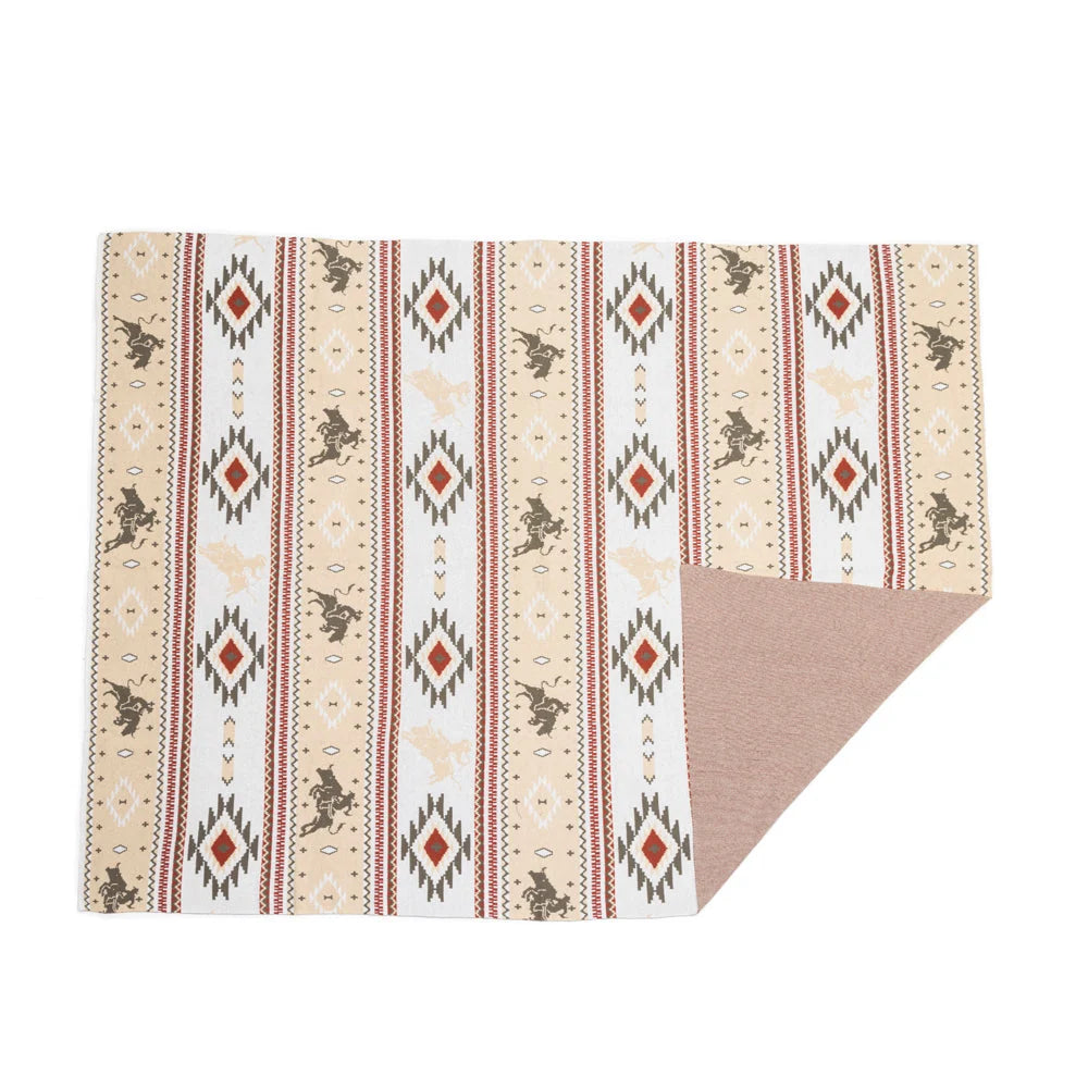 Cream throw blanket with striped rows of bucking horses and red-centered geometric diamonds.