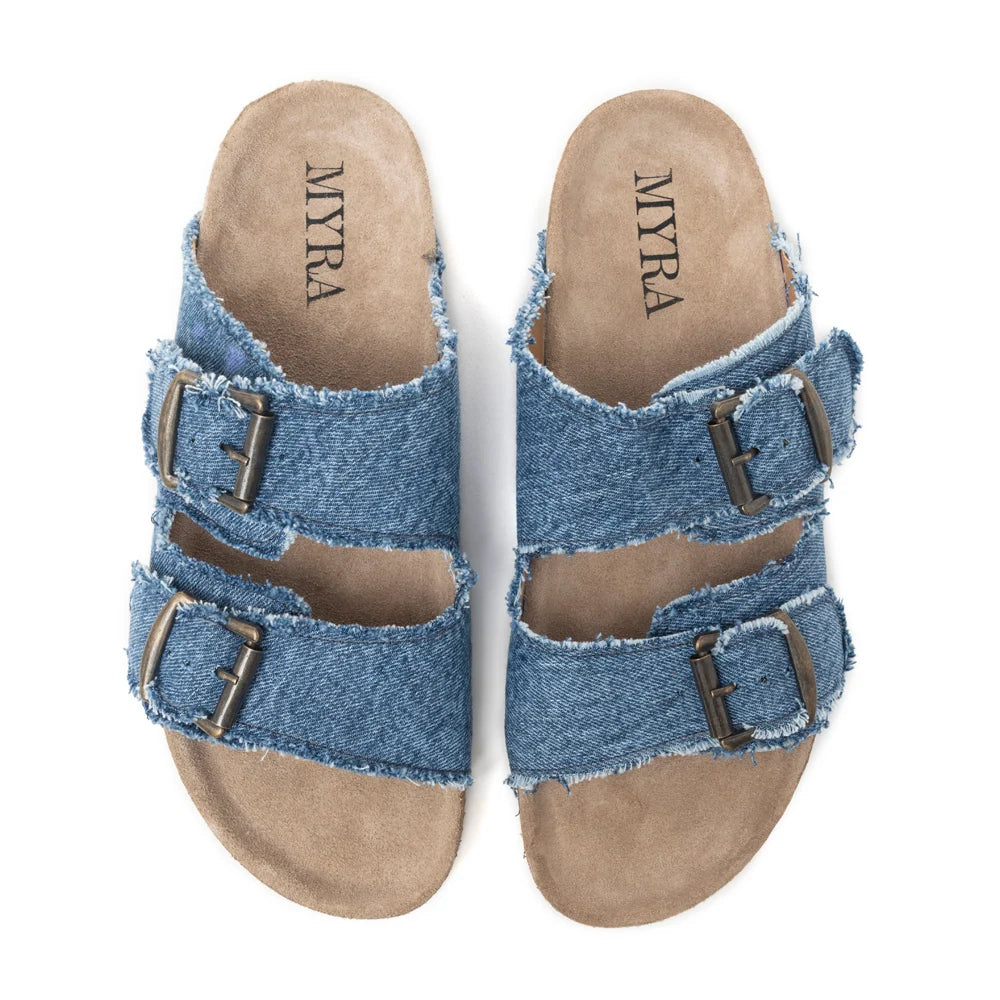 Top view of Myra Blue Ridge Denim Sandals with frayed blue denim straps, double metal buckles, and tan footbeds.