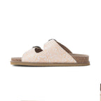 Side profile of Myra Desert Lily Antique White sandal showing embossed leather and cork footbed.
