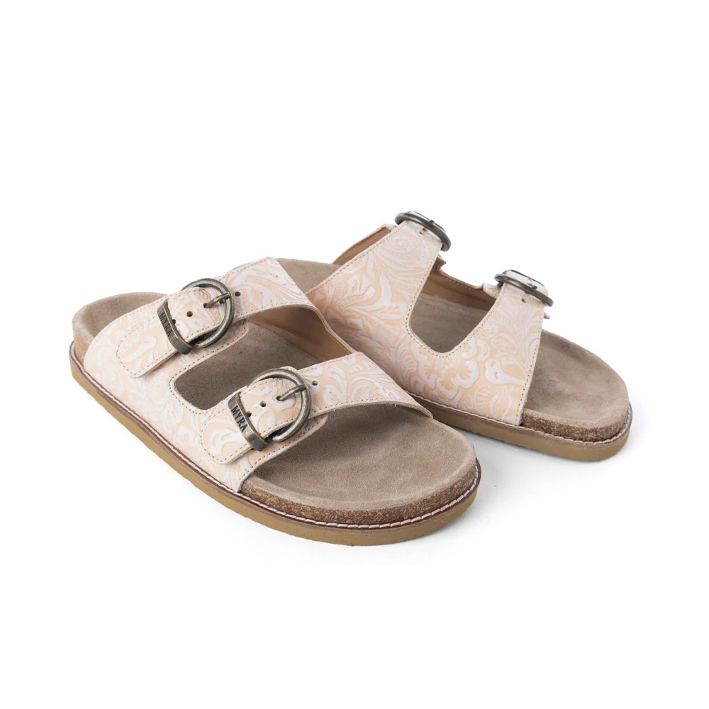 Pair of Myra Desert Lily Antique White sandals showing embossed leather straps and buckle details.
