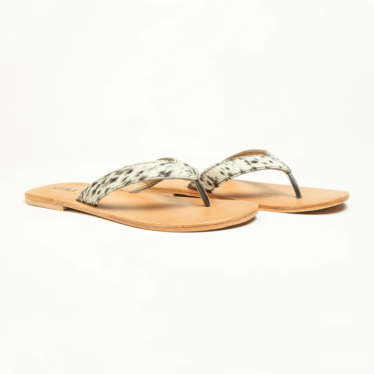 Angled view of Myra Echo Valley thong sandals with spotted ivory cowhide straps