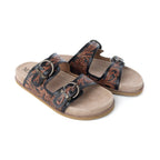 Angled view of Myra Canyon Ember sandals showing brown tooling, metal buckles, and tan footbeds.