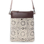 Myra Ruggy crossbody bag with a cream and dark gray geometric front panel, brown leather trim, and shoulder strap.