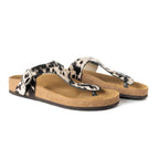 Pair of Myra Chino thong sandals with black and white hair-on cowhide straps and cork soles, angled side view