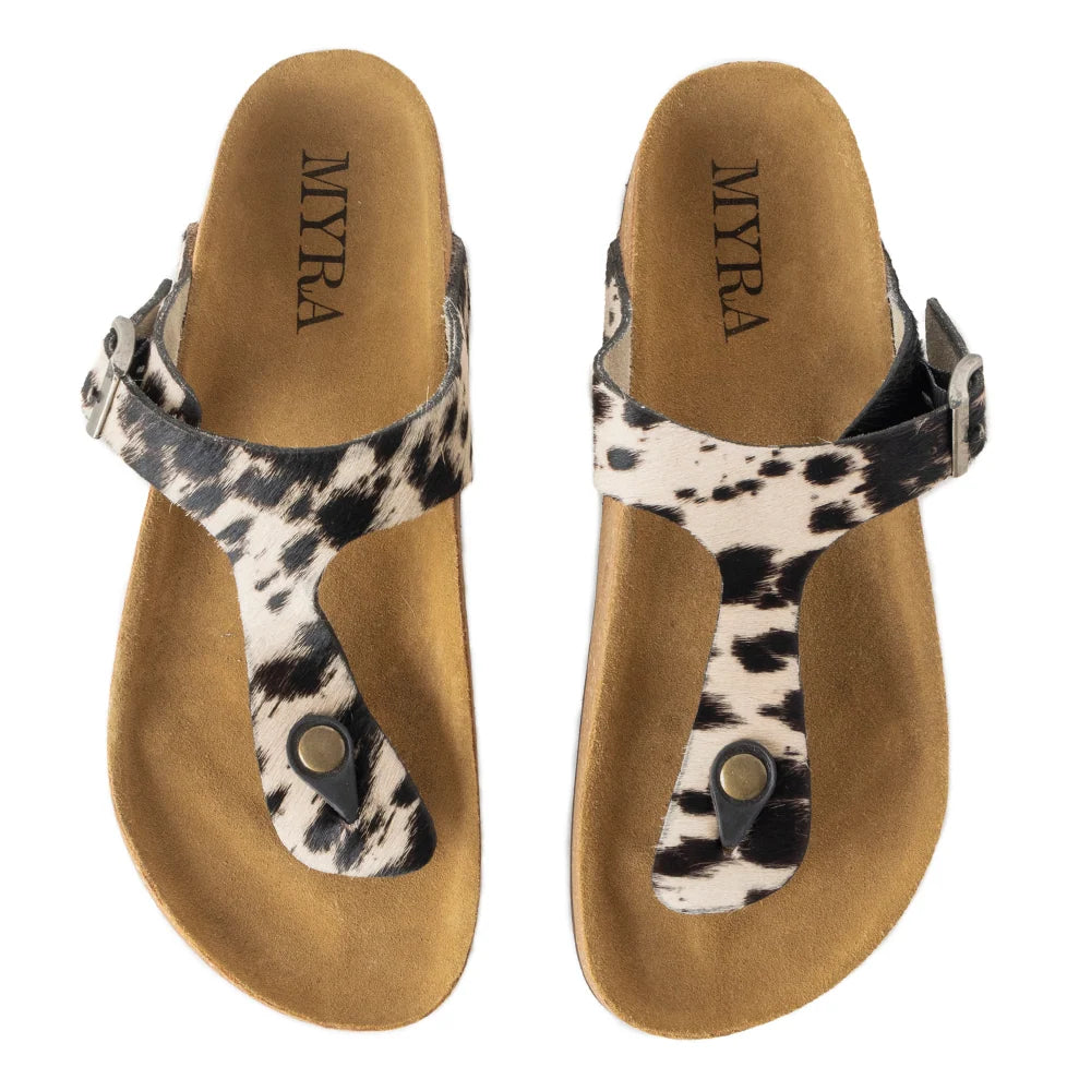 Myra Chino hair-on leather sandals in black and white cowhide print, top view of the pair showing adjustable buckle straps and cork footbeds