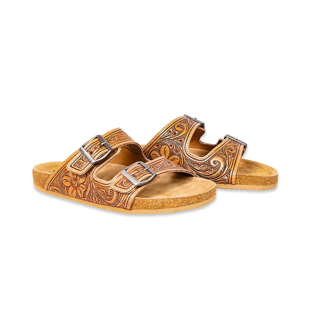 Angled view of Myra Darla Trail leather sandals showing floral tooling, metal buckles, and cork soles.