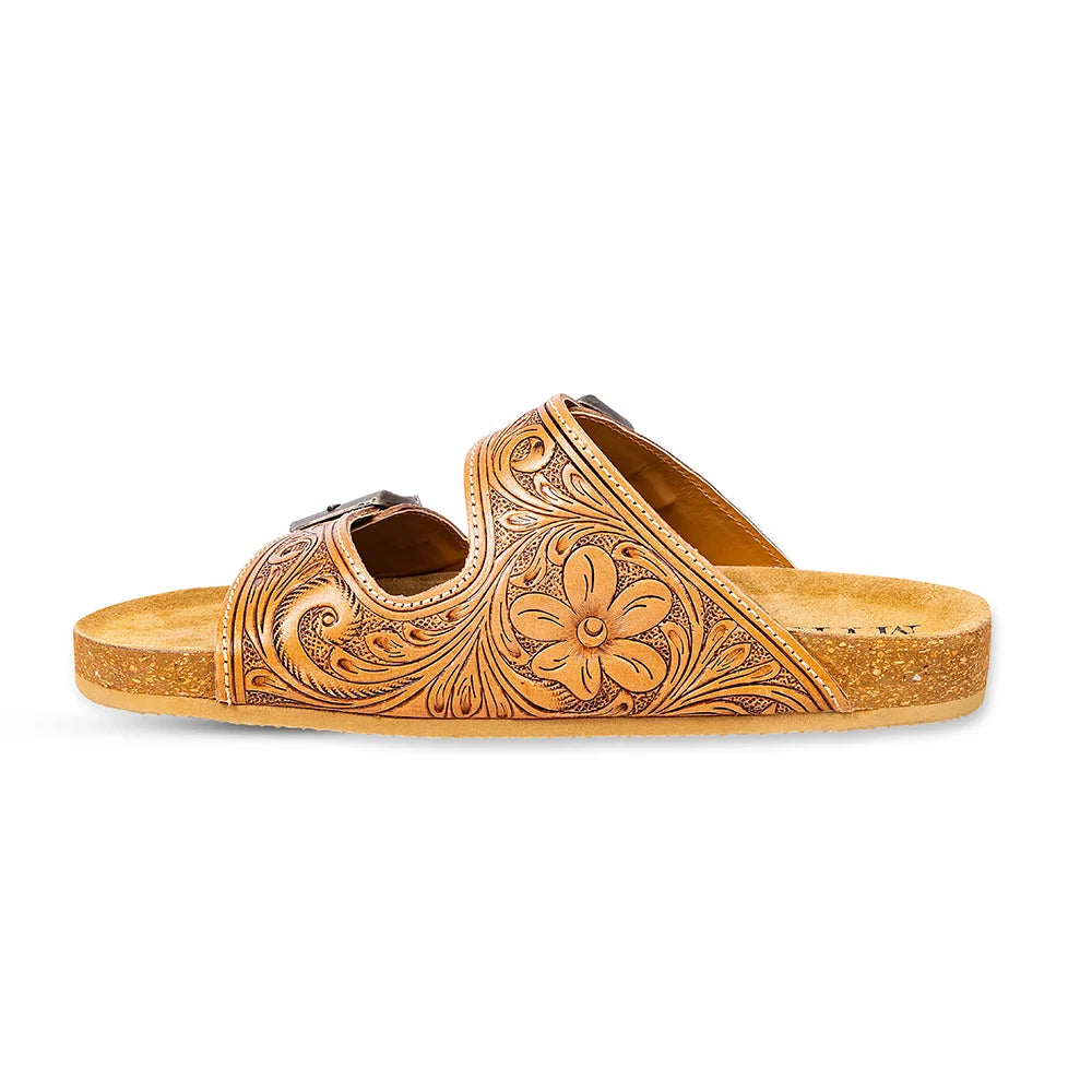 Side view of a Myra Darla Trail sandal showing hand-tooled floral and scroll details above the cork sole.