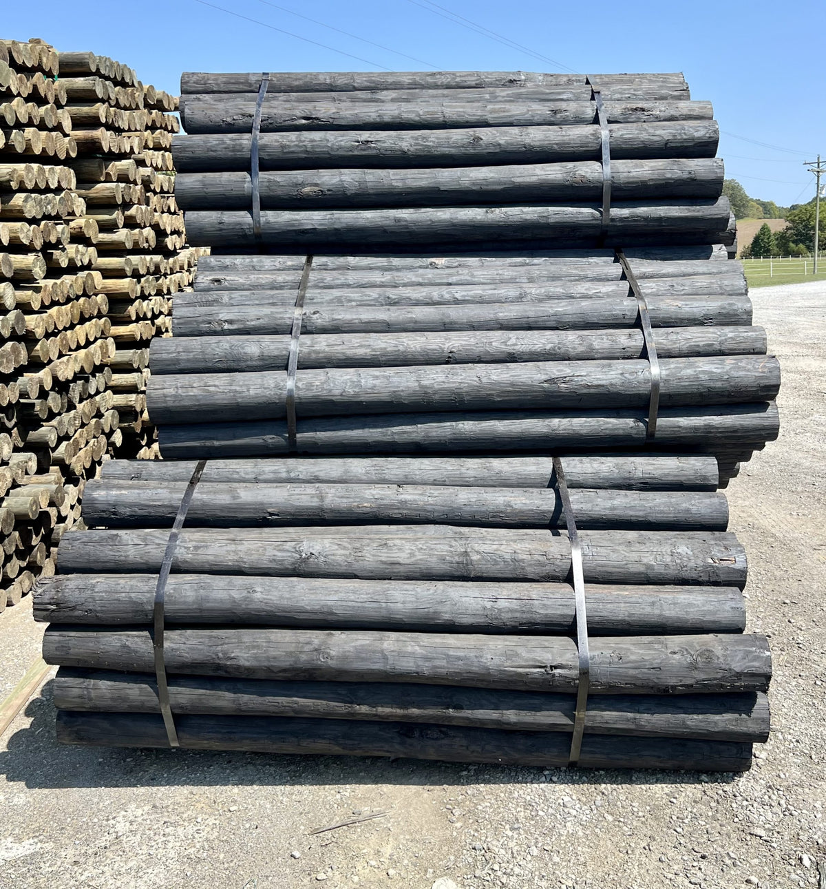 Strapped bundles of dark creosote-treated wood posts