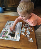 Child assembling the Porch Swing Buddies pet-themed tray puzzle with colorful dog and cat pieces