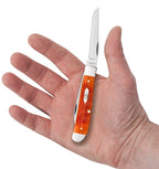 Open Case Tequila Sunrise Bone Mini Trapper resting in a hand for size comparison