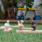 Three Schleich Chicken Friends figures on wooden blocks in the grass