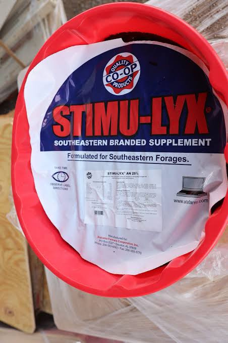 Top view of a red STIMU-LYX supplement tub with a CO-OP product label.