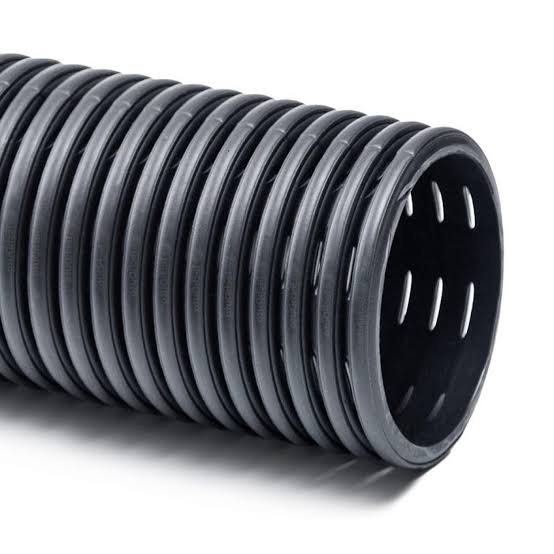 Close-up of black corrugated perforated drainage pipe showing the open end and drainage slots.