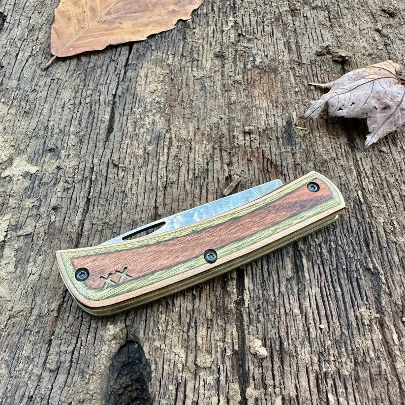 Closed Case XR Sod Buster Jr. Camo Supreme DymaLux knife resting on weathered wood