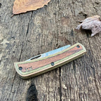 Closed Case XR Sod Buster Jr. Camo Supreme DymaLux knife resting on weathered wood