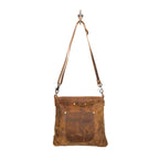 Western-inspired upcycled leather shoulder bag with exterior zip pocket