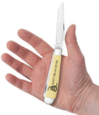Case Trapper pocket knife with yellow handle held in hand on a white background